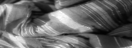 Blur of softly flowing fabric with horizontal black and silver stripes, capturing the interplay of light on a textured surface. The subtle sheen enhances the fabric's elegance and depth.の写真素材