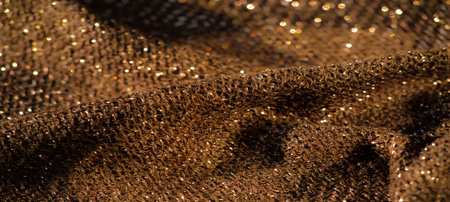 Blur A close-up view of dark golden glittering textured fabric with intricate patterns and shimmering highlights capturing the soft folds and rich surface detail ideal for luxurious fabric backgroundsの写真素材