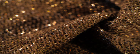 Blurred shot of crumpled shimmering fabric with a soft, glittering texture. The subtle sparkle and...