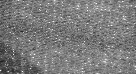 Blur of black fabric with sparkling highlights, creating a sophisticated and luxurious look. The rich texture and shining details make it ideal for fashion, textiles, or abstract design themes.の写真素材