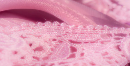 Blur of delicate pink lace resting on shimmering satin fabric, blending the intricacy of the lace...