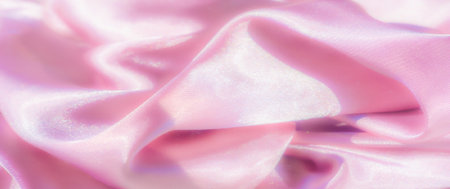 A soft and silky pink satin fabric captured in gentle, flowing folds The surface reflects light in a way that enhances the luxurious and glossy texture, creating a delicate yet glamorous visual effectの写真素材
