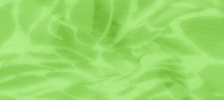 Blurred close-up of light green fabric with flowing abstract patterns that evoke softness and subtle...