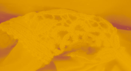 Blur of intricate yellow lace fabric showcasing a delicate pattern in soft focus The image emphasizes the texture and complexity of the material offering a subtle and elegant design for textile loversの写真素材