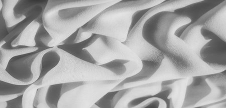Blurred monochromatic folds of soft-textured fabric with gentle shadows create a dynamic contrast between light and dark. The flowing nature of the fabric adds a sense of elegance and grace.の写真素材