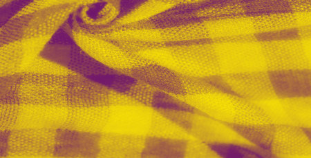 Blur of yellow checkered fabric with soft creases and textured patterns. The folds create an elegant...