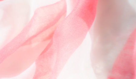 Blurred folds of soft pink and white fabric create an intricate pattern of delicate curves and...