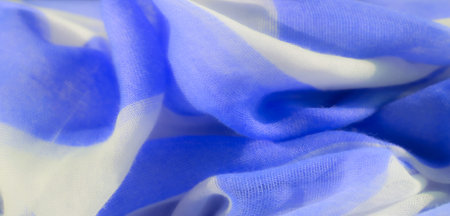 Blurred blue and white fabric with soft, flowing folds. The lightweight material has a gentle texture that creates a smooth, airy appearance with a calm and serene design.の写真素材