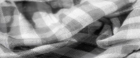 Blur of finely woven checkered fabric in grayscale, featuring soft, delicate folds and smooth textures. The intricate pattern highlights the subtle interplay of light and dark in the fabric weave.の写真素材