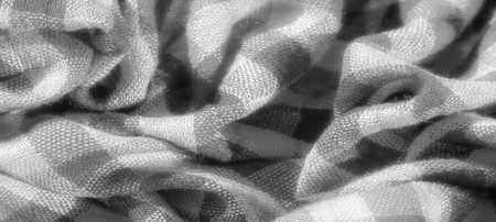 Blur of finely woven checkered fabric in grayscale, featuring soft, delicate folds and smooth textures. The intricate pattern highlights the subtle interplay of light and dark in the fabric weave.の写真素材