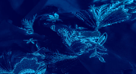 Blur of rich blue fabric draped gracefully, creating intricate folds and a soft, smooth texture. The interplay of shadows and highlights adds depth, enhancing its luxurious and calming appearanceの写真素材
