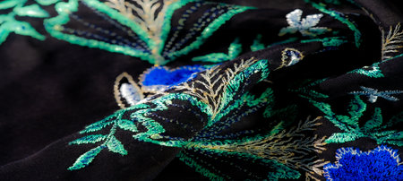 Blur of a midnight blue fabric with ornate, glowing embroidery, capturing delicate floral and leafy patterns that add depth and elegance to the soft textile surfaceの写真素材