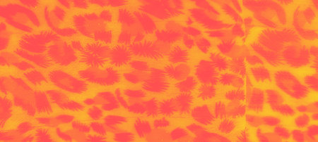 Blurred abstract patterns on bright orange and yellow fabric, mimicking natural shapes with a bold,...
