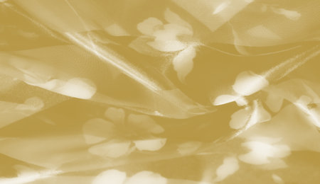 Blur of textured yellow fabric with intricate folds, capturing a soft glow and gentle movement. The material reflects light delicately, enhancing the fabric's rich and luxurious appeal.の写真素材