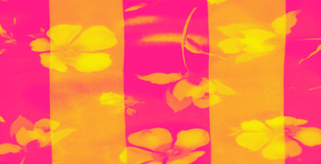 Blur of vibrant pink and yellow floral patterns overlaying soft, translucent fabric with gentle folds, creating a radiant and abstract visual texture with a glowing warmth.の写真素材