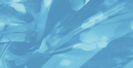 Blur of blue fabric with delicate floral hints and soft, radiant highlights flowing across its gentle folds, creating a peaceful and dreamlike ambiance.の写真素材