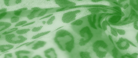 Blurred abstract green fabric with flowing folds and leopard-inspired spots. The fabric's texture is...