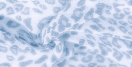 Blur effect on delicate blue and white fabric, featuring leopard-inspired abstract spots. The texture and soft folds bring a sense of depth, ideal for fashion and textile design.の写真素材