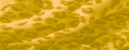 Blur of yellow fabric featuring a subtle leopard pattern and soft folds. The fabric's warm, gentle tones create a cozy, inviting background texture for textile themes.の写真素材