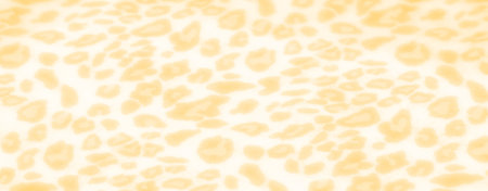 Blur Bright yellow fabric adorned with a bold leopard pattern. The subtle folds and soft texture...