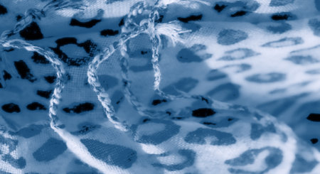 Blur effect emphasizes the blue abstract leopard spots on white fabric, creating a textured, flowing appearance that exudes elegance and tranquility.の写真素材