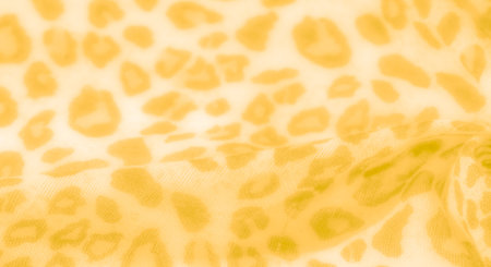 Blurred yellow fabric with an organic leopard-inspired pattern, combining softness with a bold design, suitable for stylish fashion and decor projects.の写真素材