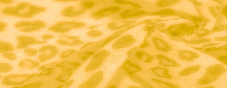 Blurred yellow textile with soft animal print accents, creating a warm and inviting pattern that...