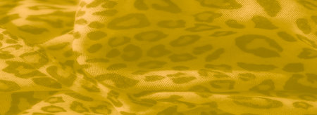 Blur of yellow fabric with subtle leopard-inspired patterns and smooth folds, creating a gentle yet intricate aesthetic suitable for warm, textured designsの写真素材