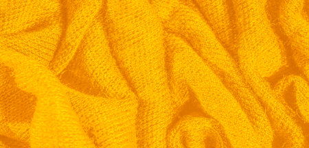 Blur. The image captures soft, flowing folds of bright yellow fabric, showing its vibrant hue and warm texture. The natural creases create an inviting, abstract pattern across the textile surface.の写真素材
