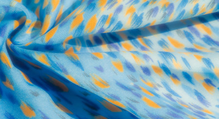 Blur of textured blue fabric with scattered yellow and light purple patterns, giving it a vibrant...
