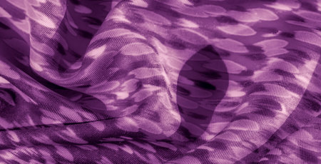 Blur of textured purple fabric with abstract spotted designs, layered with soft folds and light...