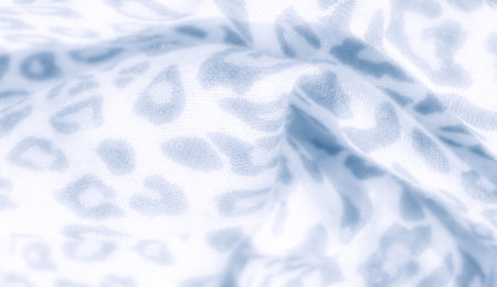 Blur: Soft focus image of blue and white fabric with a detailed leopard print design. The gentle creases create depth, emphasizing the intricate pattern across the textile.の写真素材