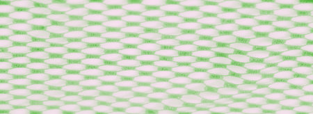 Blur of a green lace fabric with a delicate honeycomb pattern, showing intricate hexagonal shapes...