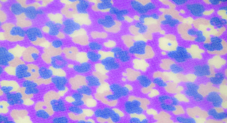 Blur of purple and blue abstract floral patterns flowing across sheer fabric, creating a dreamy,...