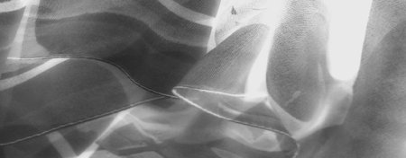 Blurred grayscale fabric with flowing lines and soft tonal transitions, showcasing a minimalist,...