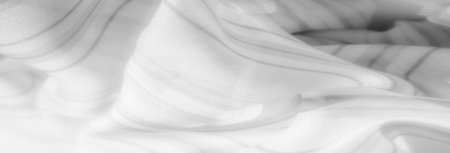 Blurred delicate white fabric flows with fine gray lines, creating a serene and ethereal effect. The gentle, airy folds and soft texture add a sense of calm and lightness.の写真素材