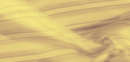 Blur of yellow fabric with soft folds and subtle shadowed stripes, creating a harmonious, gentle pattern. The smooth texture enhances the fabric's elegance and calming quality.の写真素材