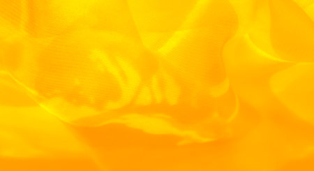 Blur of yellow fabric creating soft and gentle curves. The textured surface and vivid yellow color evoke a sense of lightness and warmth, offering a serene and elegant visual for various designs.の写真素材