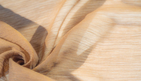 Blur. This photograph showcases beige fabric with intricate folds and light play, highlighting the soft textures and elegant flow, perfect for abstract backgrounds or textile designs.の写真素材
