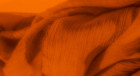 Blur Intricate orange fabric texture with soft folds and shadows, displaying rich details and a warm...
