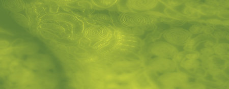 Blur of green fabric with glowing, intricate swirl patterns. This fabric's flowing design and soft...