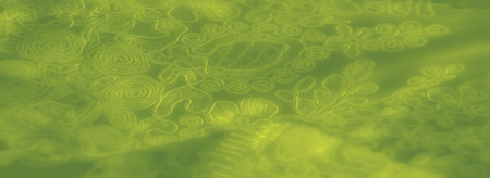 Blur emphasizes green fabric with embroidered swirls and loops, providing a textured, luxurious...