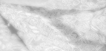 lur captures intricate, swirling lace patterns on white fabric, displaying delicate textures and layered embroidery. The close-up highlights fine craftsmanship and soft fabric detailsの写真素材