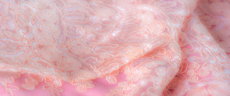 Blur, a close-up view of delicate peach-colored lace fabric featuring intricate swirls and floral embroidery. Soft textures and gentle curves create an elegant and feminine appearance.の写真素材