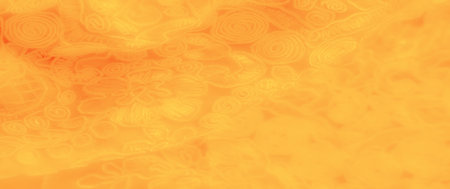 Blur â Close-up of a yellow fabric with intricate, swirling spirals and floral accents, adding depth and texture to the soft textile. Ideal for design projects needing warm and intricate backgroundsの写真素材