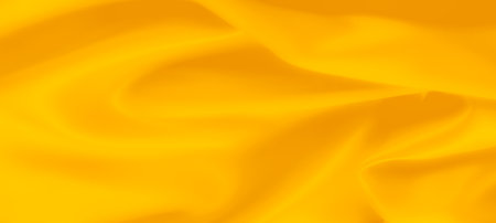 Blur yellow fabric in gentle folds with a vibrant, warm tone, capturing soft, smooth textures. The flowing form and bright hue make it ideal for backgrounds, textile art, and design elementsの写真素材