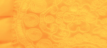 Blur. Soft yellow fabric filled with subtle, swirling floral patterns that seem to flow organically. The gentle folds add depth, creating an inviting visual warmth.の写真素材