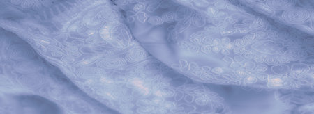 Blur. Elegant light blue fabric with intricate embroidery, featuring a blend of floral and swirl patterns. The soft lighting and gentle folds create a luxurious, calming atmosphere.の写真素材
