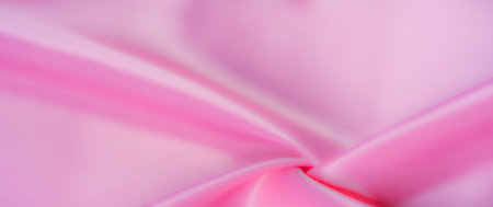 Blur: Lush pink satin fabric with a smooth texture, arranged in soft, flowing folds. The subtle reflections on its surface give the fabric an exquisite, luxurious appeal.の写真素材