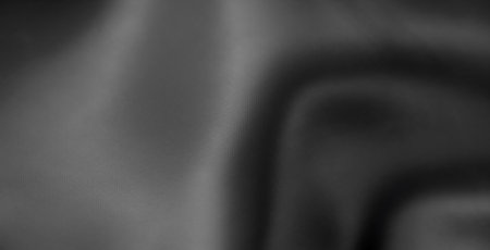 Blur of folded gray fabric in close-up, showing a soft, seamless texture with subtle shadows and highlights. This minimalist textile pattern exudes elegance and sophistication.の写真素材